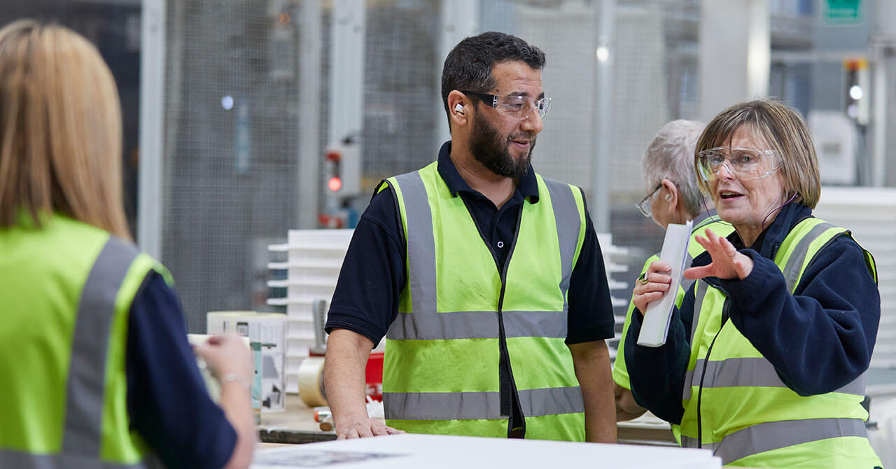 People talking in a safety vest